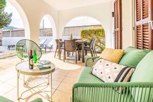 a living room with a green couch and a table at Villa Monsy 1 in El Port