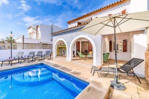 a villa with a swimming pool and an umbrella at Villa Monsy 1 in El Port