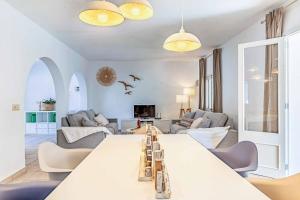 a living room with a large white table and chairs at Villa Monsy 1 in El Port