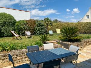 a blue table and chairs in a garden at Indigo - Maison les pieds dans l'eau à Damgan in Damgan
