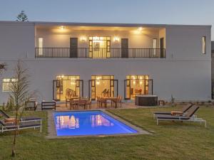 a house with a swimming pool in the yard at Glow Boutique Suites in Hermanus