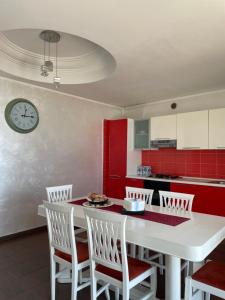 a kitchen with a white table and chairs and a clock at B&B SALERNO IN in Salerno