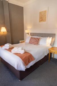 een hotelkamer met een groot bed met handdoeken erop bij The Warwick Arms Hotel in Warwick