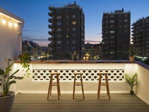 two bar stools on a balcony with a city skyline at BCN: ¡Exclusivos y cerca del Camp Nou! in El Arrabal