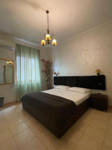 une chambre avec un grand lit et un lustre dans l'établissement B&B SALERNO IN, à Salerne