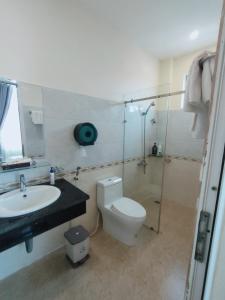 ein Bad mit einem WC, einem Waschbecken und einer Dusche in der Unterkunft Kim Huong Quang Hotel in Phu Quoc
