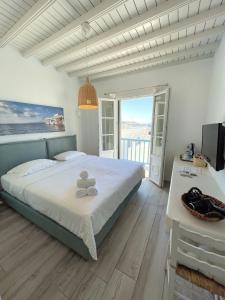 a bedroom with a large bed and a balcony at Lefteris in Mikonos