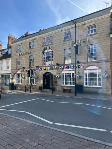 um grande edifício de tijolos com uma rua em frente em The Warwick Arms Hotel em Warwick