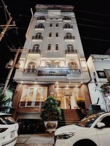 ein großes weißes Gebäude mit Treppen und Balkonen in der Unterkunft Kim Huong Quang Hotel in Phu Quoc