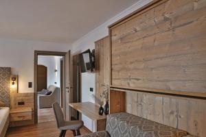 Zimmer mit einer Holzwand, einem Schreibtisch und einem Stuhl in der Unterkunft Ferien Bauernhof Maurachhof in St. Johann im Pongau