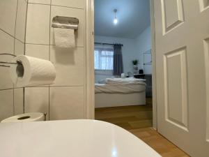 een witte badkamer met een toilet en een slaapkamer bij Nice Living Serviced Accommodations 4 in Coventry