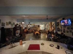 a living room with people sitting at tables and a tv at Auberge Chez Hassan in Imsouane