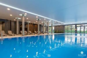 basen w hotelu z niebieską wodą w obiekcie Jantar Apartamenty - Boutique Polanki Park SPA w Kołobrzegu