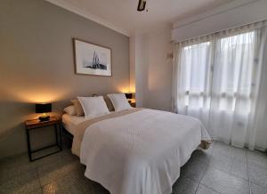 a bedroom with a white bed and a window at Apartamento del Mar - Playa Muchavista in El Campello +35 photos
