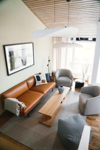 uma sala de estar com um sofá de couro castanho e uma mesa em Barsebäck Resort Hus em Löddeköpinge