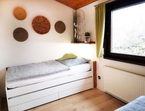 a small room with a bed and a window at Ferienhaus LENA im Sauerland direkt am Hennesee in Meschede