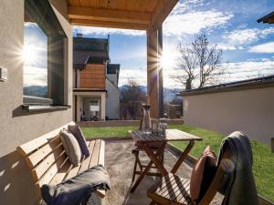 un patio con un banco de madera y una mesa en Berg Apartment Barbara, en Hopfgarten im Brixental