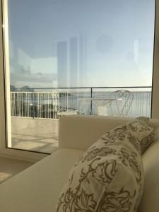 Bett mit Kissen und Blick auf einen Balkon in der Unterkunft Blue Island Villa Caterina in Casteldaccia