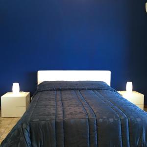 ein blaues Schlafzimmer mit einem Bett mit zwei Lichtern in der Unterkunft Blue Island Villa Caterina in Casteldaccia