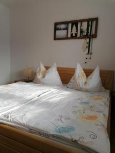 ein Bett mit weißer Bettwäsche und Kissen darauf in der Unterkunft Appartement Alpenglück in Aich