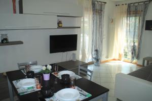 a kitchen and living room with a table and a television at Casa Vela in Riva del Garda