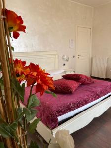 a bed with red pillows and flowers in a room at B&B SALERNO IN in Salerno