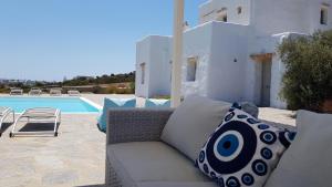 eine Couch auf einer Terrasse neben einem Pool in der Unterkunft Villa Laguna Blu in Kampos Paros