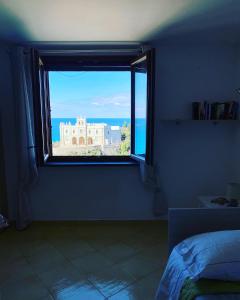 a bedroom with a window with a view of the ocean at BlueMind in Tropea