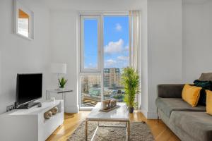 a living room with a couch and a large window at Two Bedroom Serviced Apartment in Stratford in London