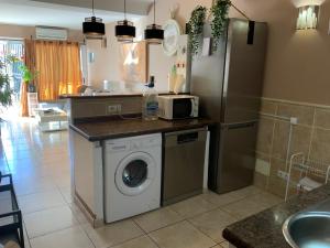 a kitchen with a washing machine and a refrigerator at Villa Bahamas private heated pool close to town. in San Bartolomé de Tirajana