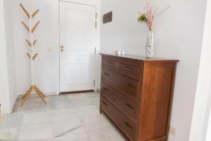 Cette chambre dispose d'une commode en bois avec un vase. dans l'établissement Titan, edificio Hipercor, con Parking, à Huelva