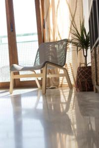 una silla de plástico sentada en una habitación con una planta en Titan, edificio Hipercor, con Parking en Huelva