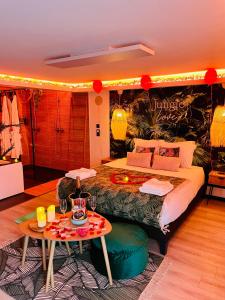 - une chambre avec un grand lit et une table dans l'établissement Loveroom Jungle Love Proche Disneyland, à Serris