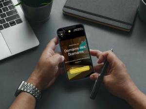 a person holding a cell phone in front of a desk at Factory, appart hotel Valenciennes in Aulnoy