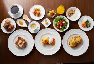 a table with plates of food and a cup of coffee at The Gate Hotel Tokyo by Hulic in Tokyo