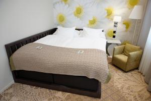 タルトゥにあるリディア ホテルのベッドルーム(大型ベッド1台、椅子付)