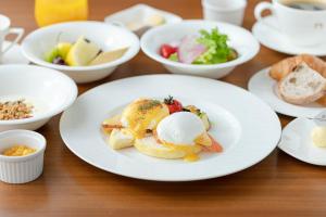 a table with plates of food and bowls of food at The Gate Hotel Kyoto Takasegawa by Hulic in Kyoto