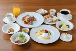 a table topped with plates of breakfast foods and coffee at The Gate Hotel Kyoto Takasegawa by Hulic in Kyoto