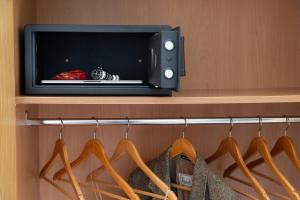 TV en un estante en un armario con perchas en Aramis Rooms, en Florencia