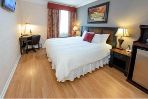 a hotel room with a large bed and a desk at Guest House at Norwalk Inn in Norwalk