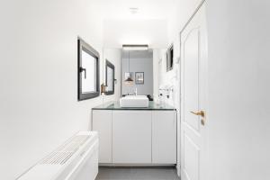 a white bathroom with a sink and a mirror at GuestReady - Casa da Alegria 8 in Porto