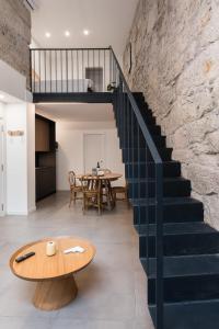 a staircase in a loft with a table and a dining room at GuestReady - Casa da Alegria 8 in Porto