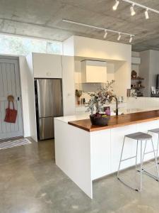 cocina con encimeras blancas y nevera de acero inoxidable en Entire stylish and bright inner city home, en Perth