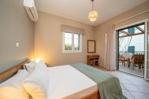 1 dormitorio con 1 cama grande y balcón en Captain's Villas, en Katelios