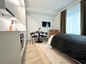 a bedroom with a bed and a table with chairs at Tammer Huoneistot - City Suite 4 - Perfect Location & Great Amenities in Tampere