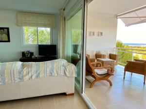 a bedroom with a bed and a chair and a balcony at Fantástico apartamento con increíble vistas in Punta Grossa