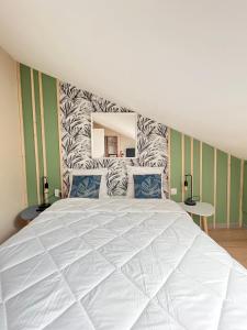 - une chambre avec un grand lit blanc et un miroir dans l'établissement Appartement 400 m du centre, à Louhans