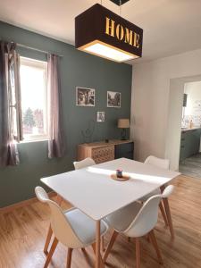 a dining room with a white table and chairs at Charmant appartement proche du centre ville in Louhans +8 photos