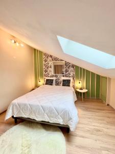 - une chambre avec un grand lit et une lucarne dans l'établissement Appartement 400 m du centre, à Louhans