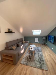 a living room with a couch and a table at Charmant appartement proche du centre ville in Louhans